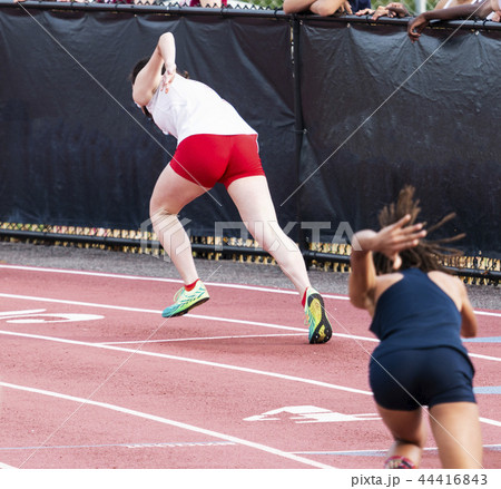 Female sprinters starting a race on a track Female sprinters starting a race on a track 44416843