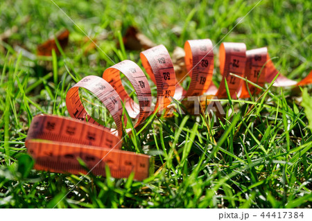 Fit centimeter on green grass measuring tape 44417384