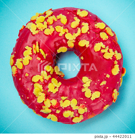 Glazed donut with colorful sprinkles on blue pastel background. 44422011