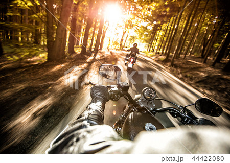 Man seat on the motorcycle on the forest road. Man seat on the motorcycle on the forest road. 44422080