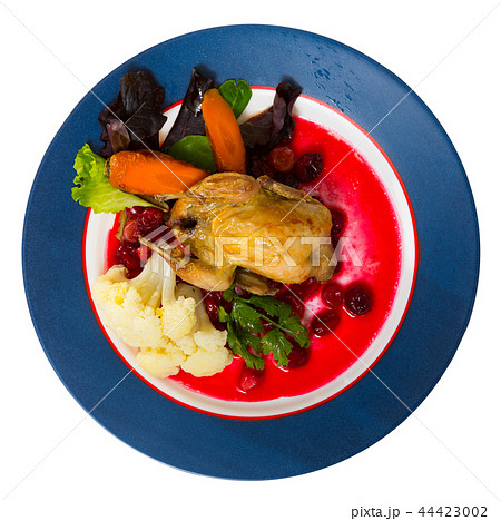 Top view of roasted quail with caramelized carrots and cranberry 44423002