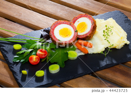 Scotch egg with pureed potatoes, carrots, tomatoes, greens 44423725