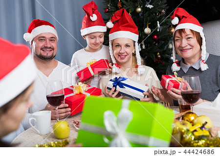 Cheerful family exchanging Christmas gifts Cheerful family exchanging Christmas gifts 44424686