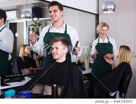 Hairdresser cutting hair of teenage Hairdresser cutting hair of teenage 44424995