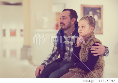 Father and small daughter looking art paintings Father and small daughter looking art paintings 44425197