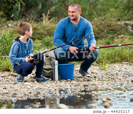 Positive father and boy fishing with rods Positive father and boy fishing with rods 44425217