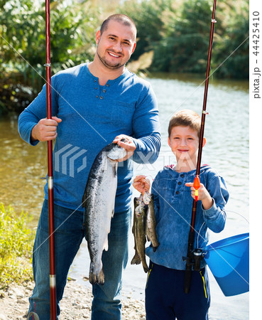 Portrait of father and son fishing with rods Portrait of father and son fishing with rods 44425410