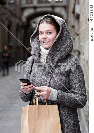 young female with mobile in hood 44425842