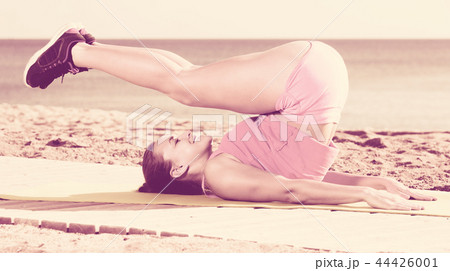 Woman doing yoga at beach 44426001
