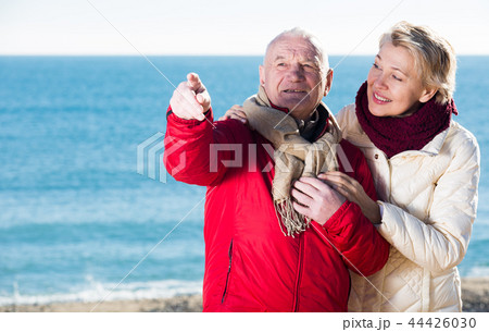 Mature couple pointing on beach 44426030
