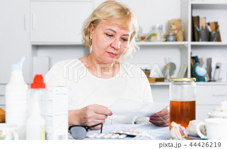 Mature woman with medicines and bills Mature woman with medicines and bills 44426219