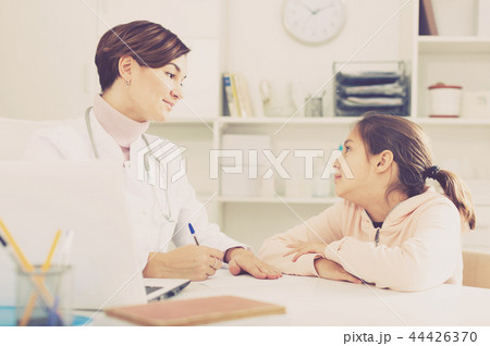 Doctor fills patient card for girl Doctor fills patient card for girl 44426370
