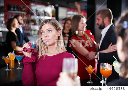 Girl upset because boyfriend flirting with other woman in bar Girl upset because boyfriend flirting with other woman in bar 44426588