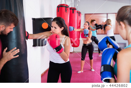 Sporty girl is boxing near punching bag in gym. 44426802