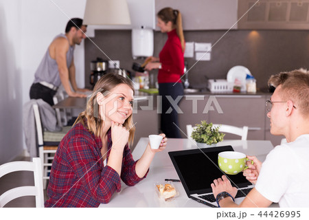Girl talking to guy in kitchen of hostel Girl talking to guy in kitchen of hostel 44426995