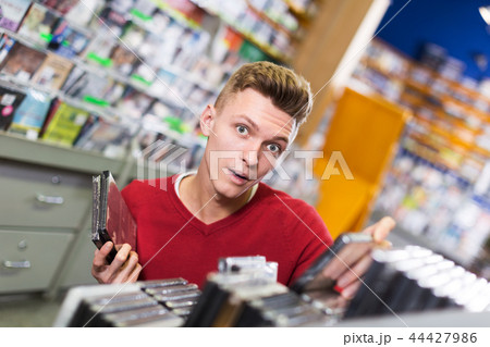 Surprised guy choosing DVD 44427986