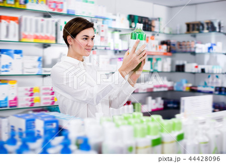 Positive woman customer browsing rows of drugs Positive woman customer browsing rows of drugs 44428096