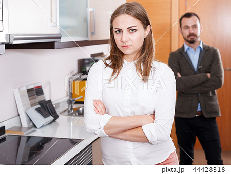 Upset girl with husband in kitchen furniture salon Upset girl with husband in kitchen furniture salon 44428318