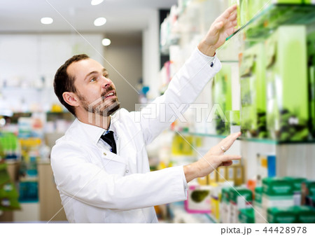 Male pharmacist searching for reliable drug Male pharmacist searching for reliable drug 44428978