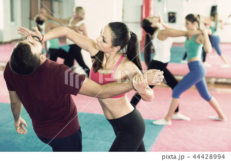 Sporty girl with her instructor are training self-defence moves 44428994