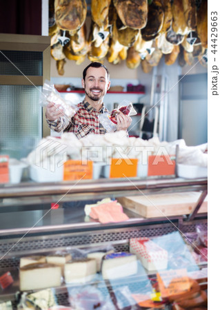 Smiling man seller showing sorts of meat Smiling man seller showing sorts of meat 44429663