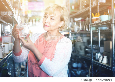 customer female choosing glass sugar bowl in the dishes shop customer female choosing glass sugar bowl in the dishes shop 44429694
