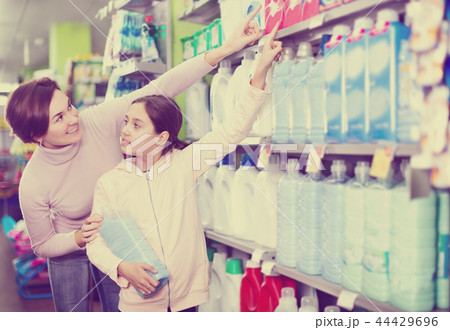 Woman with girl looking for cleaners in supermarket Woman with girl looking for cleaners in supermarket 44429696