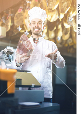 Seller showing piece of meat in butcher’s store Seller showing piece of meat in butcher’s store 44429728