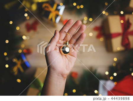 Hand Holding Small Gold Bauble Christmas Hand Holding Small Gold Bauble Christmas 44439898