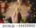 Hand Holding Bitcoin Above Christmas Decoration 44439900