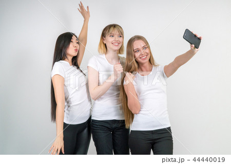 Beautiful funny girls make selfie. Girls in white T-shirts. Beautiful funny girls make selfie. Girls in white T-shirts. 44440019