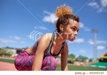 Confident young sportswoman getting ready to run a distance at the stadium. Confident young sportswoman getting ready to run a distance at the stadium. 44440197
