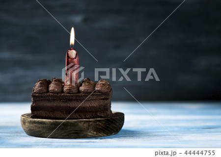 bloody middle finger with a lit wick on a cake 44444755