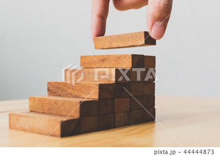 Hand arranging wood block stacking as step stair 44444873