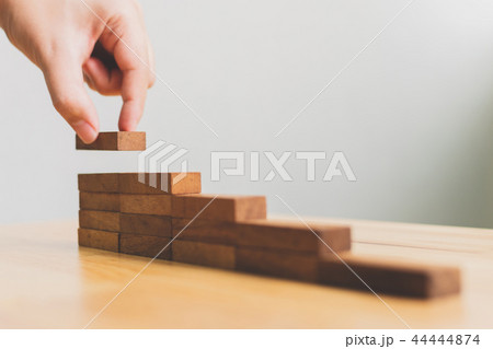 Hand arranging wood block stacking as step stair Hand arranging wood block stacking as step stair 44444874