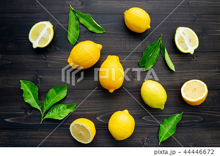 Fresh lemons and  lemons leaves on dark wooden. 44446672
