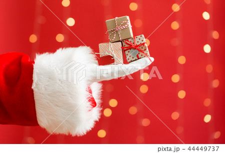 Santa holding small Christmas gift boxes Santa holding small Christmas gift boxes 44449737