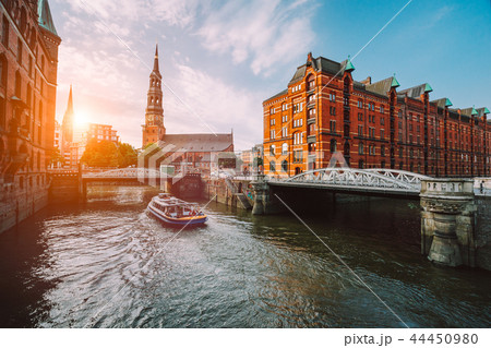Touristic cruise boat on a channel with bridges in the old warehouse district Speicherstadt in 44450980