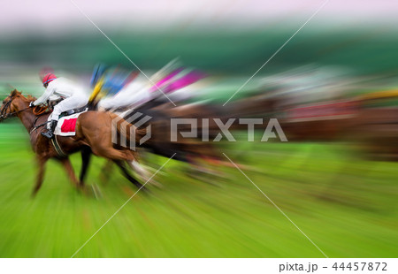 Race horses with jockeys on the home straight 44457872