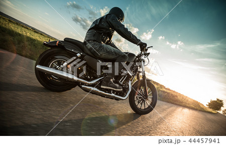 Man riding sportster motorcycle during sunset. Man riding sportster motorcycle during sunset. 44457941
