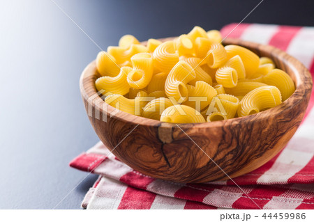 Uncooked elbow macaroni in bowl. 44459986