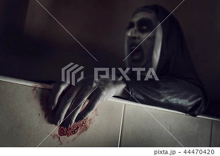 frightening evil nun with blood in her hands 44470420