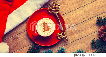 red cup of Cappuccino with key and Christmas hat 44473366