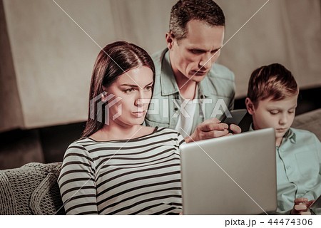 Concentrated brunette female working at her laptop Concentrated brunette female working at her laptop 44474306