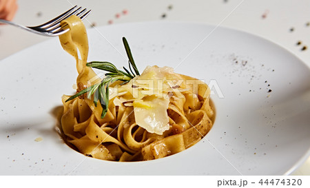 Close-up italian pasta plate with grated parmesan cheese and basil leaf Close-up italian pasta plate with grated parmesan cheese and basil leaf 44474320
