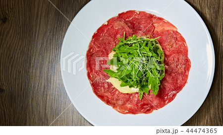 The meat carpaccio with salad. Shallow dof. The meat carpaccio with salad. Shallow dof. 44474365