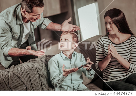 Worried mother looking at her son and husband 44474377