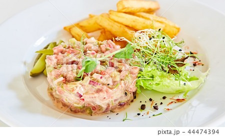 Meat tartar with french fries and vegetable salad. 44474394