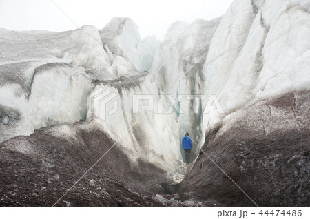 A free climber with an ice ax in his hand stands at the foot of the Great Glacier next to an epic 44474486