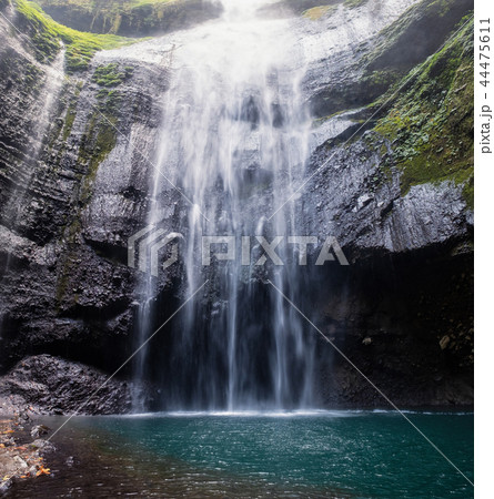 Majestic waterfall flowing on rocky cliff Majestic waterfall flowing on rocky cliff 44475611